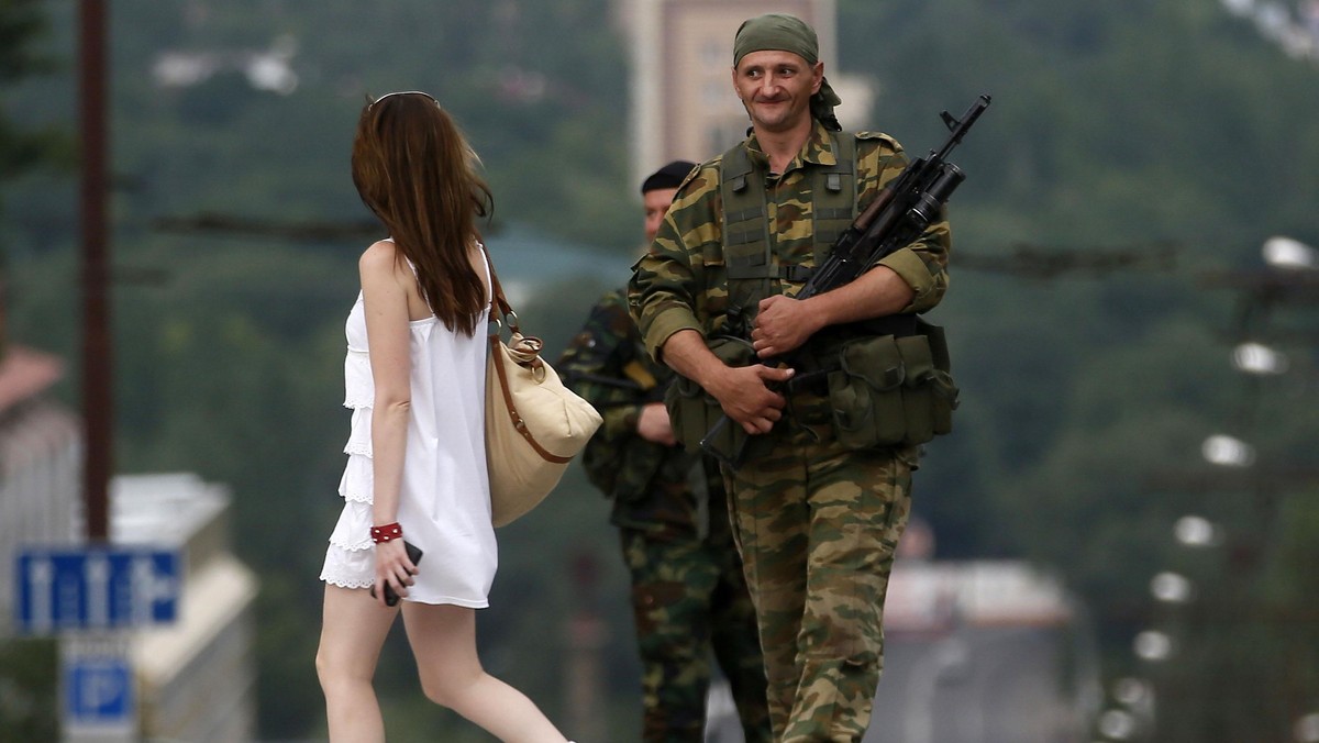 An armed man smiles at a girl