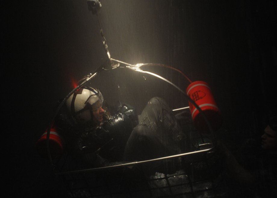 A student at the Aviation Survival Training Center ascends on a hoist during a simulated night exercise as part of an aircrew refresher course in Jacksonville, Florida.