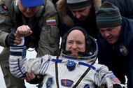 Ground personnel help U.S. astronaut Scott Kelly to get out of a Soyuz capsule shortly after landing