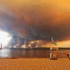 Posetioci plaže odmaraju se na plaži Mučik na obali jezera Lakano u Lakanou, na jugozapadu Francuske, dok požar besni u Žirondi, 24. jul 2026.