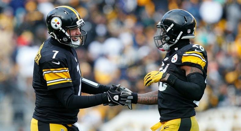 Le'Veon Bell (R) of the Pittsburgh Steelers celebrates with quarterback Ben Roethlisberger after he rushed for a touchdown against the Miami Dolphins on January 8, 2017