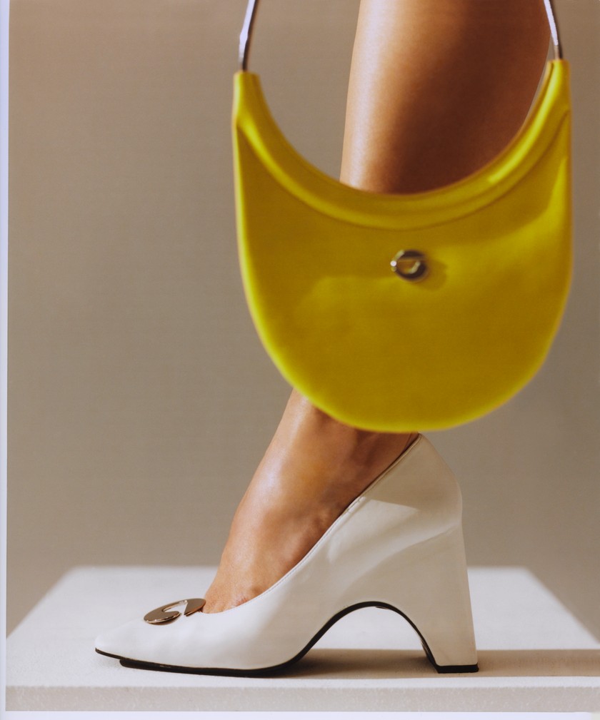 Schultertasche Ring Swipe aus Leder und Square-Toe-Pumps mit Logo-Applikation, beides von Coperni.