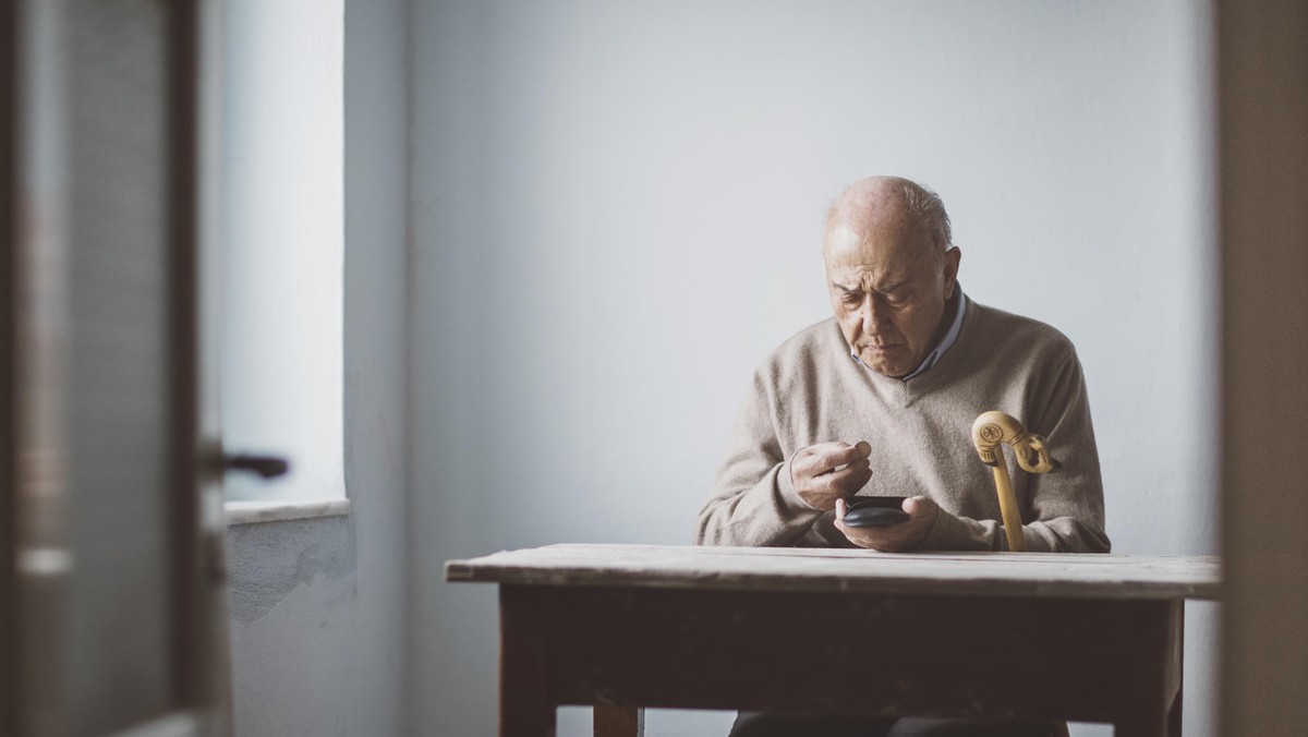 An elderly man look for some money from his wallet