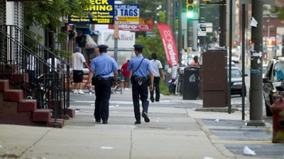 Philadelphia Police officers patrol a street.