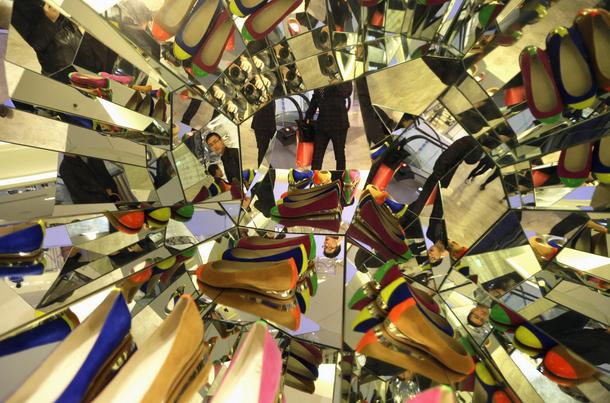 A customer looks at shoes displayed in a mirror showcase at the newly-opened Galeries Lafayette Beij