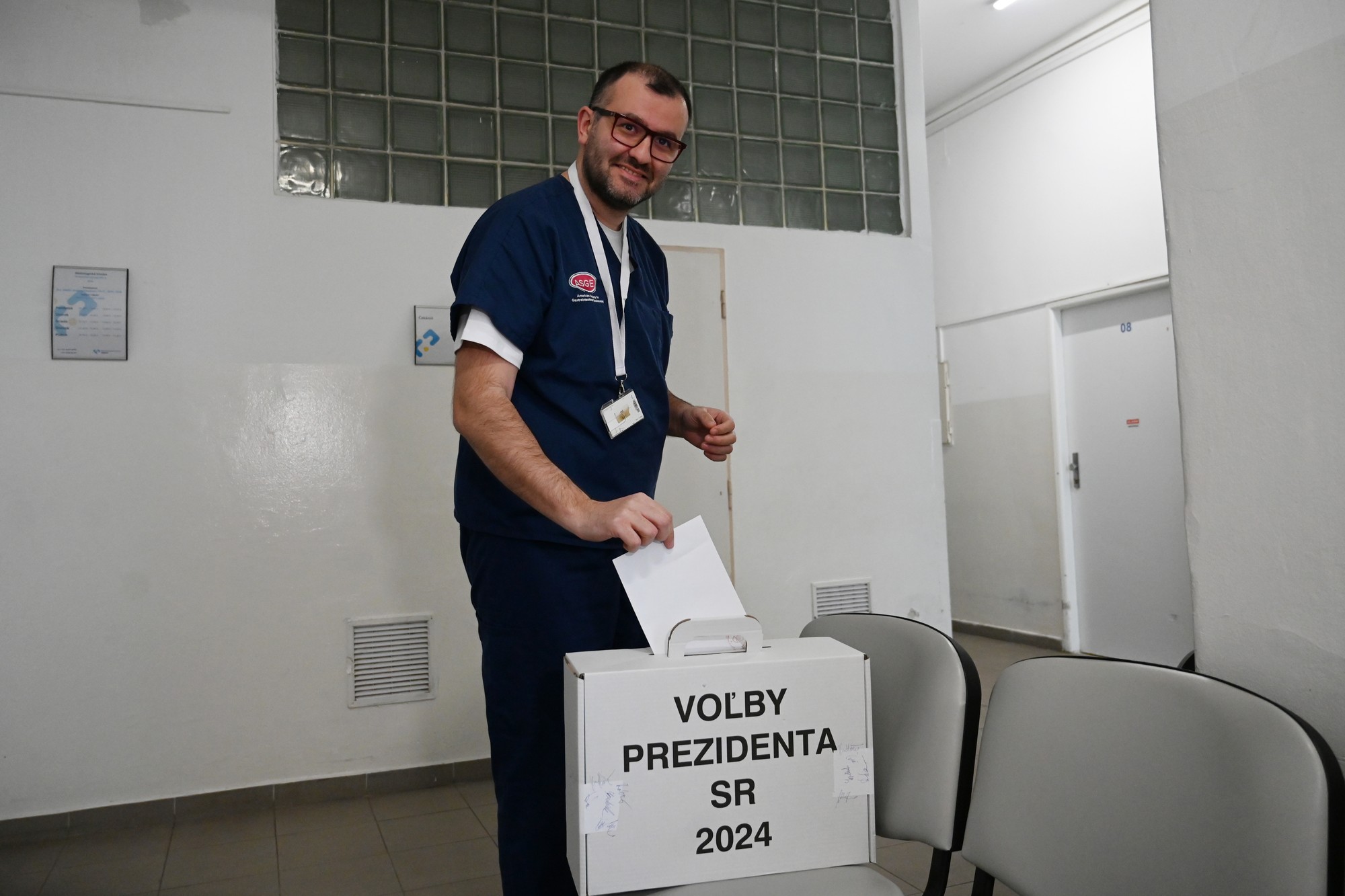 Lekár Fakultnej nemocnice Trnava Rastislav Husťak vhadzuje obálku s hlasovacím lístkom do prenosnej volebnej schránky v budove nemocnice v Trnave.