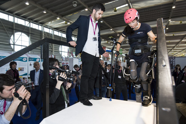 Silke Pan, niepełnosprawna sportsmenka ścigająca się na Handbike, prezentuje wynalazek o nazwie "Twiice". Twiice jest egzoszkieletem kończyn dolnych, umożliwiającym osobom z paraliżem dwukończynowym wstanie, chodzenie a nawet wchodzenie po schodach. Prace nad rozwojem modułowego egzoszkieletu rozpoczęły się w lutym 2015 r. w EPFL (Ecole polytechnique federale de Lausanne). fot. EPA / JEAN-CHRISTOPHE BOTT