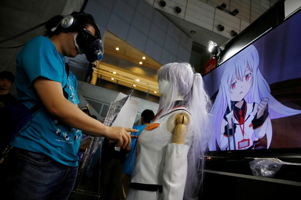 A man touches a mannequin as he tries out a M2 Co.Ltd's E-mote system at Tokyo Game Show 2016 in C