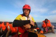 Spanish rescuer Daniel Calvelo carries a four-day-old baby girl into a RHIB, during a search and res