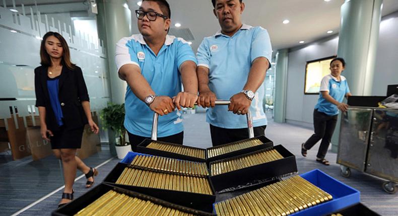 Employees push a trolley laden with crates of one kilogram gold bars at the YLG Bullion International Co. headquarters in Bangkok, Thailand.