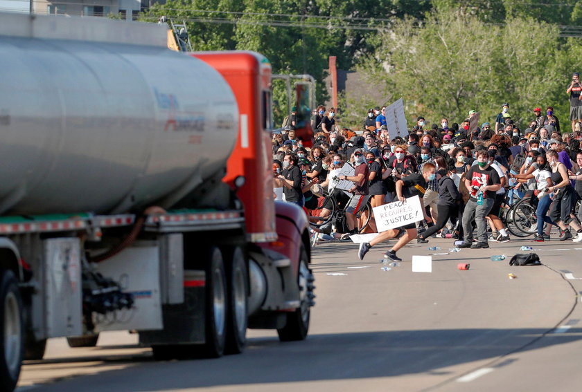Protesters scale a truck that was driven into a rally