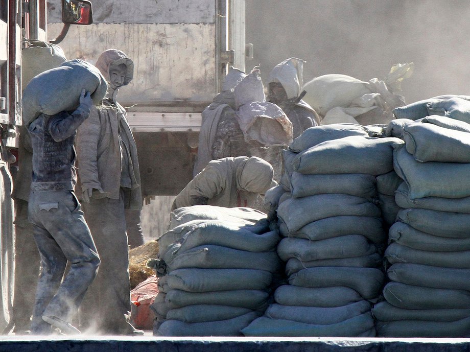 Workers unload bags of cement from a truck near the North Korean border in China in 2014.