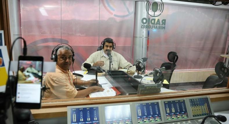 Venezuelan president Nicolas Maduro (R) speaks during his radio broadcast 'La Hora de la salsa' (Salsa Time), in Caracas, on November 15, 2016