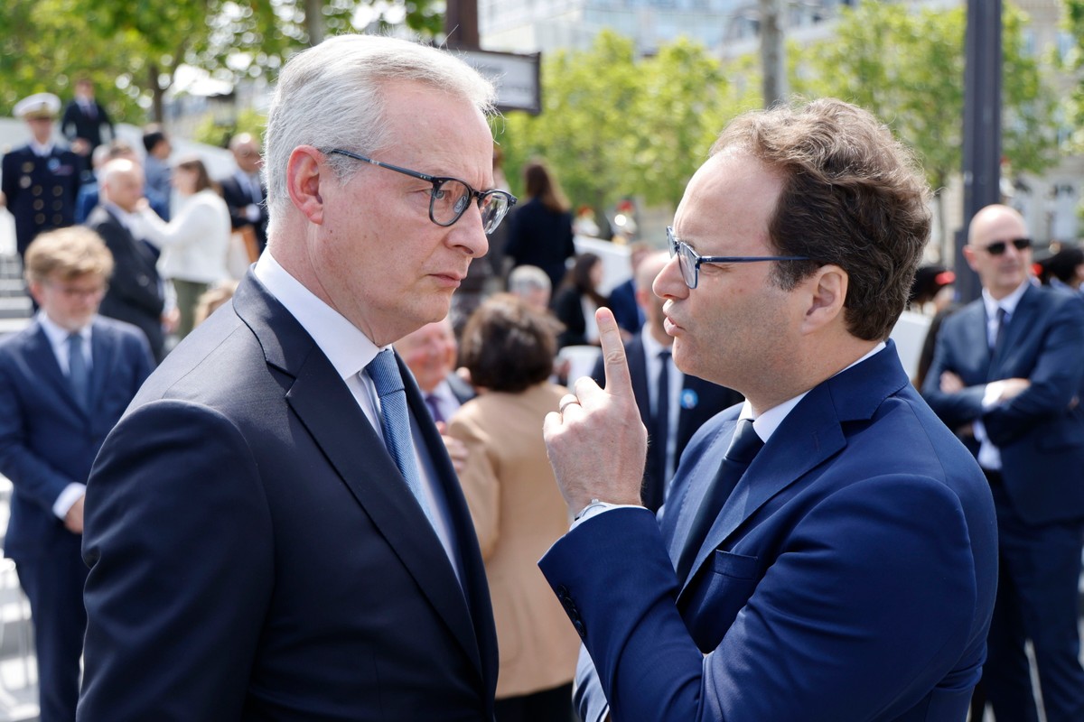 Francuski minister gospodarki i finansów Bruno Le Maire rozmawia z francuskim posłem Sylvainem Maillardem, czekając na przyjazd prezydenta USA przed ceremonią w ramach jego wizyty państwowej we Francji, pod Łukiem Triumfalnym w Paryżu