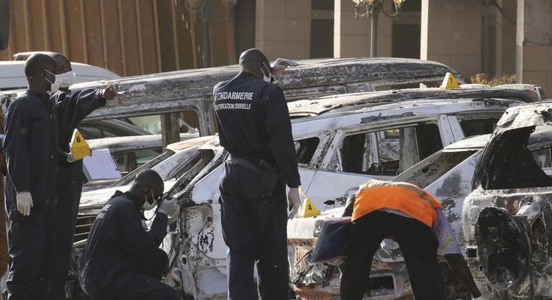 Gendarmes inspect burnt-out vehicles outside the Splendid Hotel in Ouagadougou, Burkina Faso, January 16, 2016, after security forces retook the hotel from al Qaeda fighters who seized it in an assault that killed two dozen people from at least 18 countries and marked a major escalation of Islamist militancy in West Africa. REUTERS/Joe Penney