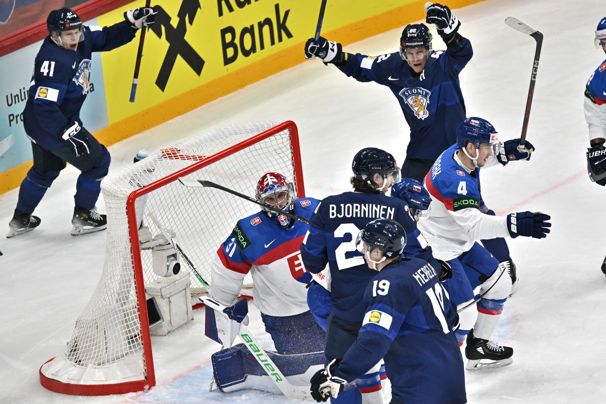 Fínski hokejisti Hannes Björninen (24), Jan-Mikael Järvinen (41) a Harri Pesonen (82) sa tešia z gólu, ktorý strelil ich spoluhráč Waltteri Merelä (19) za chrbát slovenského brankára Samuela Hlavaja, prizerá sa slovenský hokejista Dávid Mudrák (4). 