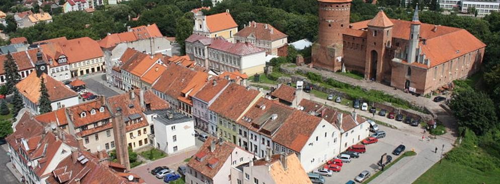 <strong>Reszel</strong>
<br></br>
Po bitwie pod Grunwaldem Reszel przeszedł pod panowanie Władysława Jagiełły, ale jeszcze jesienią 1410 przywrócono władzę zakonną. W 1440 Reszel przystąpił do Związku Pruskiego założonego w Kwidzynie, jako jedno z miast założycielskich. Tajna Rada Związku Pruskiego w dniu 4 lutego 1454 wypowiedziała posłuszeństwo władzom zakonnym. Dwa dni później opanowano większość zamków krzyżackich i biskupich. Obroniły się tylko Malbork, Sztum i Chojnice. Wojska zakonne rok później opanowały Reszel, biskupom warmińskim przekazały miasto dopiero w 1462.
<br></br>
21 sierpnia 1811 w Reszlu miał miejsce ostatni w Królestwie Prus, a także ostatni w Europie przypadek spalenia czarownicy na stosie. Ofiarą była Barbara Zdunk. Oskarżano ją jednak nie tylko o czary, ale przede wszystkim o podpalenie, bowiem w 1807 na zamku miał miejsce pożar, którego przyczyny pozostają niejasne. Proces trwał 3 lata. Sprawa winy budziła kontrowersje, jednak sąd w Królewcu zatwierdził wyrok. Przed spaleniem skazaną uduszono.
<br></br>
Fot. Ludwig Schneider / Wikimedia Commons, lic. cc-by-sa