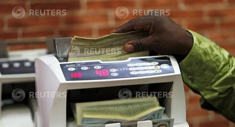 A bureau de change operator counts U.S. currency notes in Abuja, March 12, 2015. REUTERS/Afolabi Sotunde