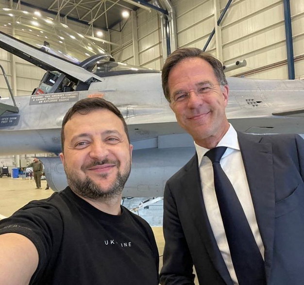Prezydent Ukrainy Wołodymyr Zełenski i premier Holandii Mark Rutte pozują do zdjęcia przed samolotami F16 po zawarciu porozumienia w sprawie dostaw. Holandia, 20 sierpnia 2023 r.