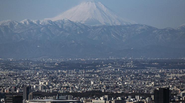 A japán főváros látképe 2021. január 29-én. A háttérben az ország jelképének számító, 3776 méteres Fudzsi hegy. Az előtérben balról a 2020-as olimpiai játékokra megépített Nemzeti Stadion. A koronavírus-járvány miatt elhalasztott ötkarikás játékokat a tervek szerint 2021. július 23. és augusztus 8. között rendezik meg.MTI/AP/Szato Kiicsiro