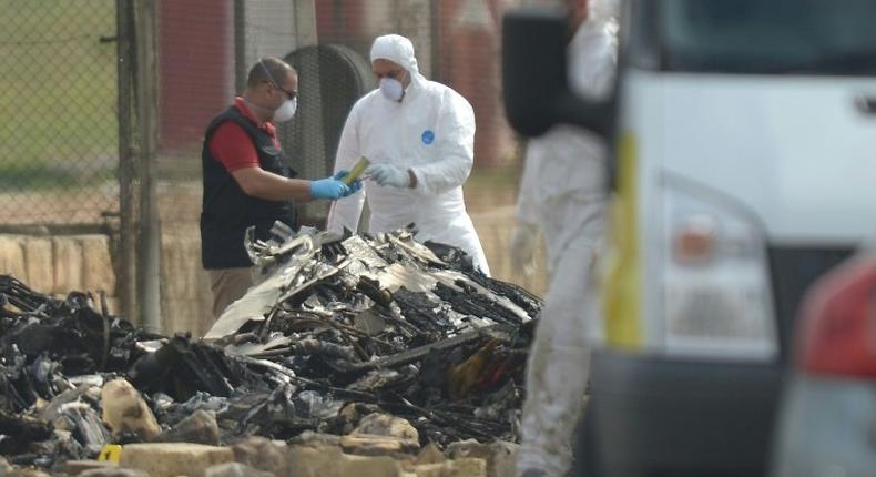 Forensics officials work at the site of a plane crash at Malta international airport on October 24, 2016