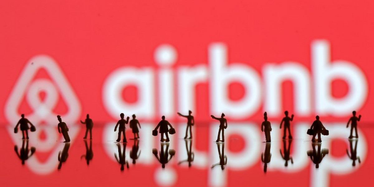 3-D-printed figures in front of the Airbnb logo.