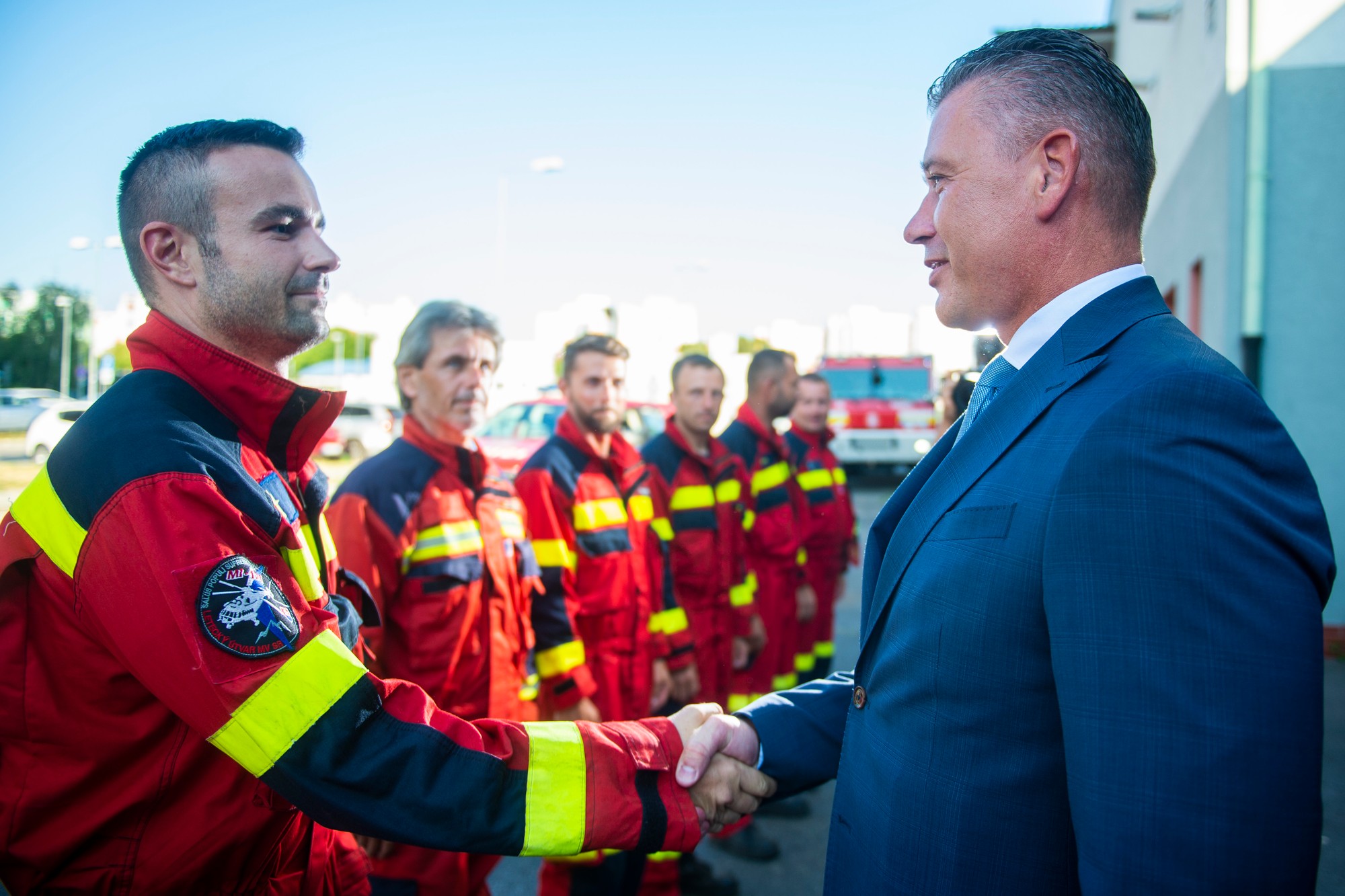 Na snímke vpravo minister vnútra SR Roman Mikulec a vľavo veliteľ tímu slovenských hasičov Richard Rehák počas privítania príslušníkov Hasičského a záchranného zboru. 