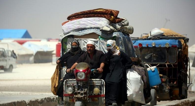 Displaced Syrians drive on June 10, 2017 at a temporary camp in the northern Syrian village of Ain Issa, where many people who fled the Islamic State group stronghold of Raqa are taking shelter