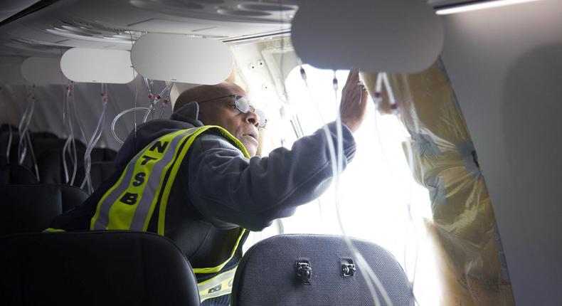 National Transportation Safety Board (NTSB) Investigator-in-Charge John Lovell examines the fuselage plug area of Alaska Airlines Flight 1282 Boeing 737-9 MAX, which was forced to make an emergency landing with a gap in the fuselage, in Portland, Oregon.NTSB via Reuters