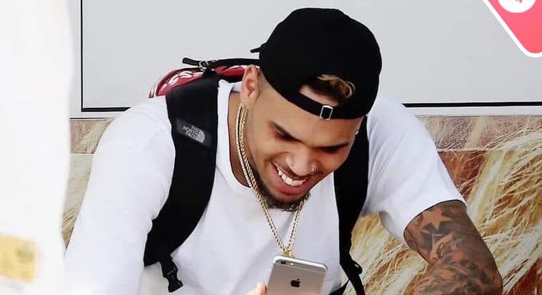 Chris Brown staring at his phone