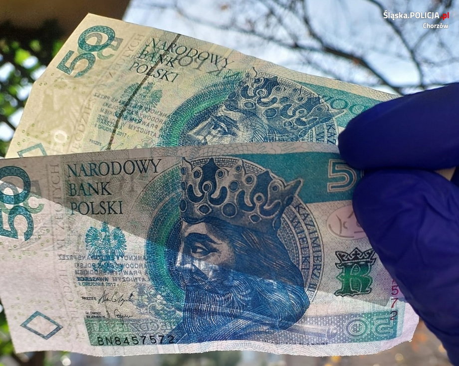 Funkcjonariusz pokazuje sfałszowane banknoty