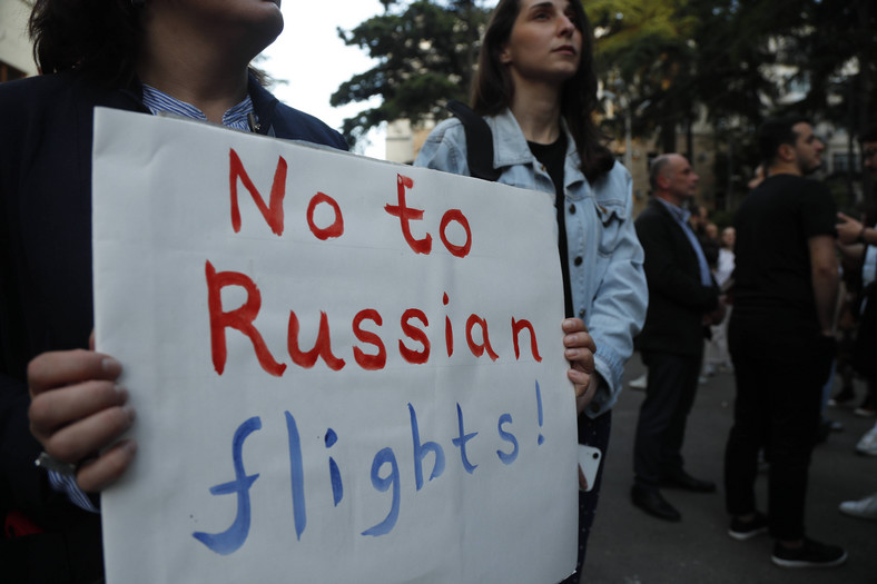 Kobieta trzymająca transparent podczas wiecu protestacyjnego przeciwko bezpośrednim lotom rosyjskich linii lotniczych do Gruzji, 16 maja 2023 r.
