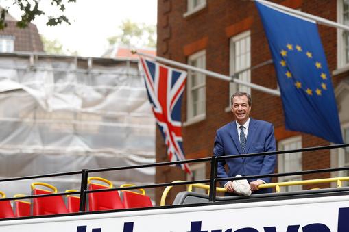 Nigel Farage passes a European Union flag as he rides a bus while campaigning against Britain's Prim