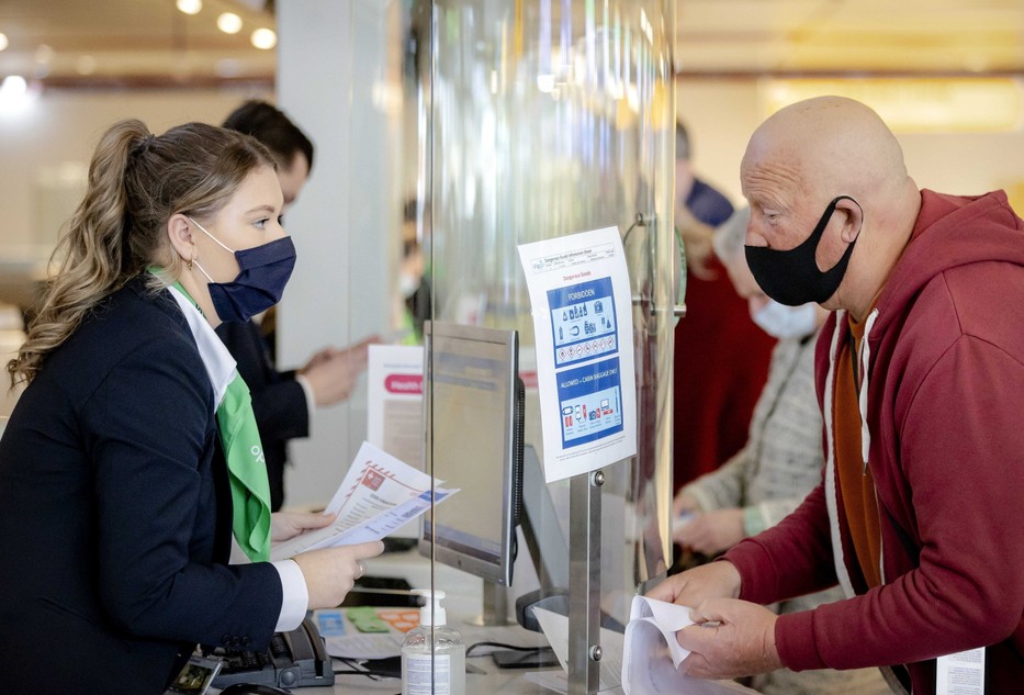 Negatív PCR-tesztjét mutatja az utasfelvételi pultnál egy utas az Amszterdamhoz közeli Schiphol repülőtéren 2021. április 12-én / MTI/EPA/ANP/Robin Van Lonkhuijsen