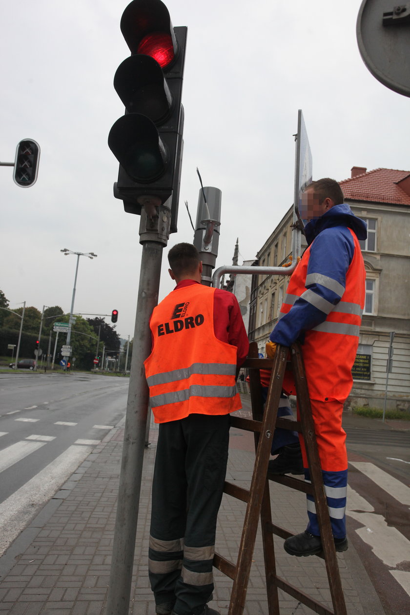 Robotnicy instalują kamery przy drodze