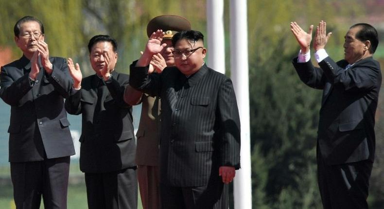 North Korea's leader Kim Jong-Un (C) waves as he attends a ceremony for the opening of a housing project in Pyongyang on April 13, 2017