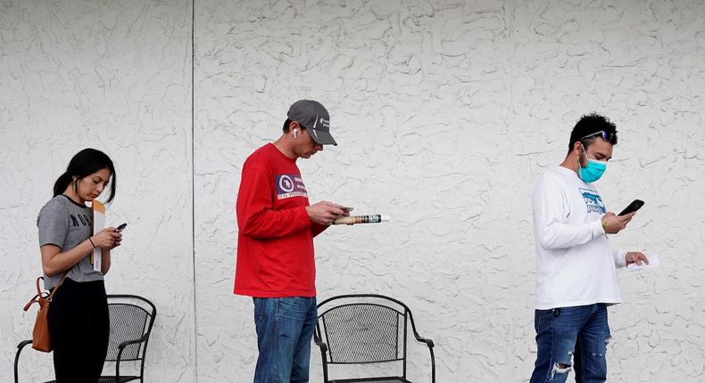 People wait on line to file for unemployment in Fayetteville, Arkansas, April 6, 2020.
