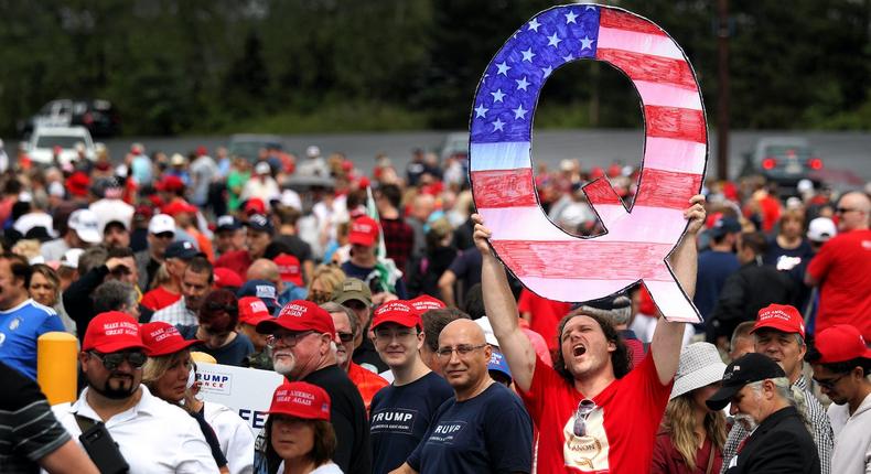 A Trump supporters holds up a large QAnon sign while waiting in line to see President Donald J. Trump at his rally on August 2, 2018.Rick Loomis/Getty Images