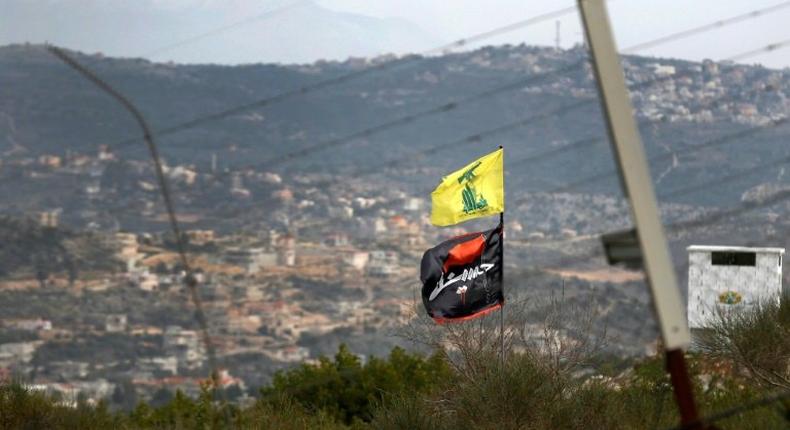 A flag of Lebanon's Hezbollah Shiite movement and a religious flag reading al-Hussein fly on the border with Israel