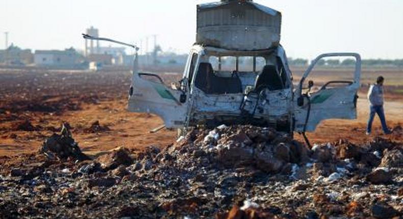 A man walks near a damaged truck at a site hit by what activists said were airstrikes carried out by the Russian air force in Karf Naseh town, Aleppo countryside, Syria December 26, 2015.