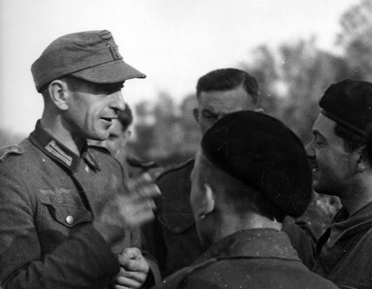 Wcielony siłą do Wehrmachtu Polak rozmawiający z żołnierzami 1 Dywizji Pancernej gen. Stanisława Maczka, Normandia 1944 r.