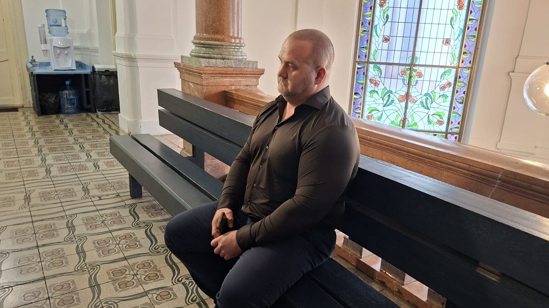 Svedok Peter Petrov čaká pred pojednávacou miestnostou.  