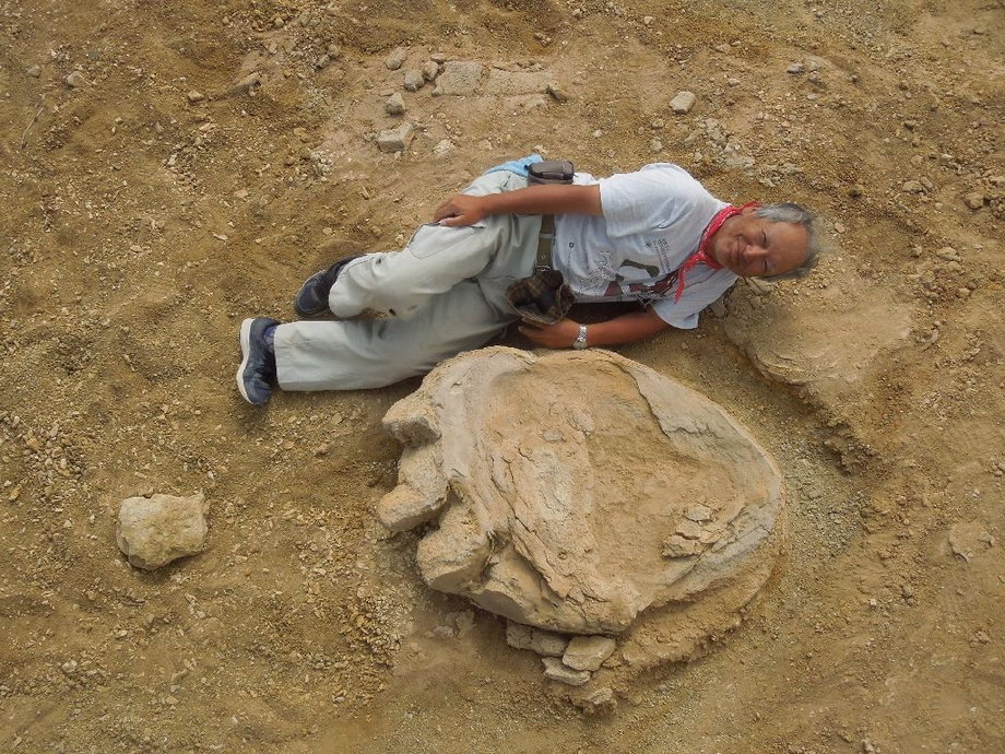 Professor Shinobu Ishigaki poses next to the dinosaur footprint in the Gobi Desert.