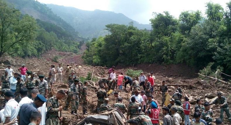 Rescuers look for survivors at the site of a landslide in Himachal Pradesh, northern India