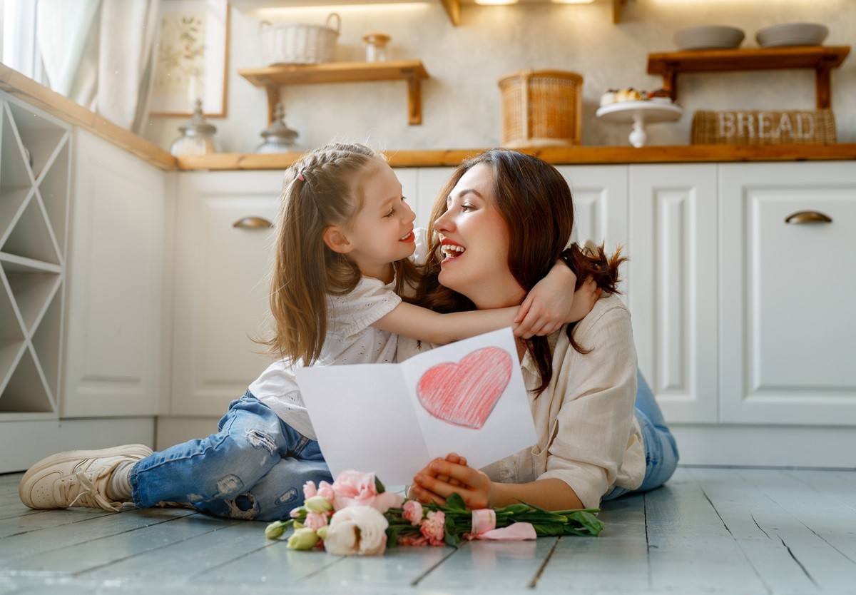 Mama z córką siedzą w kuchni na podłodze