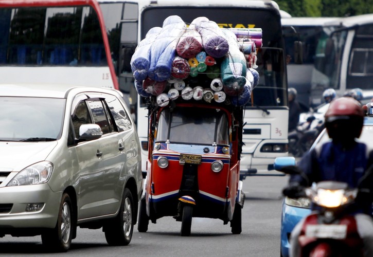 Przeładowana trójkołowa taksówka w Dżakarcie w Indonezji