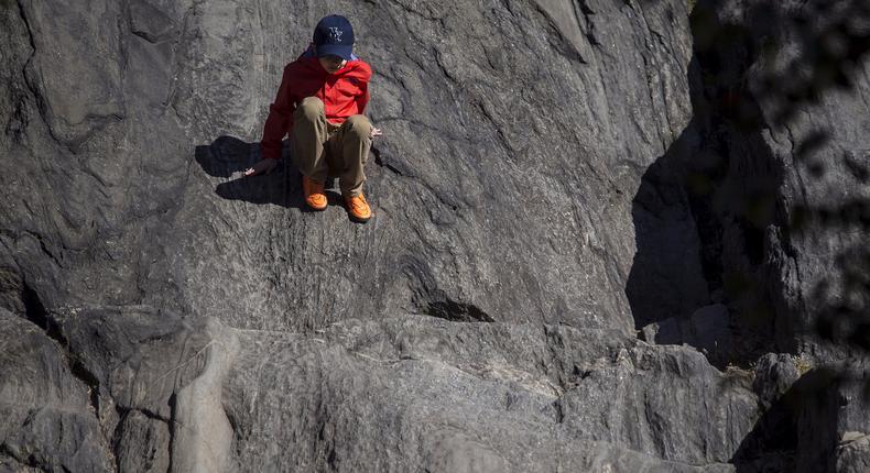 A child slides down a rock face in Central Park in the Manhattan borough of New York October 20, 2015.