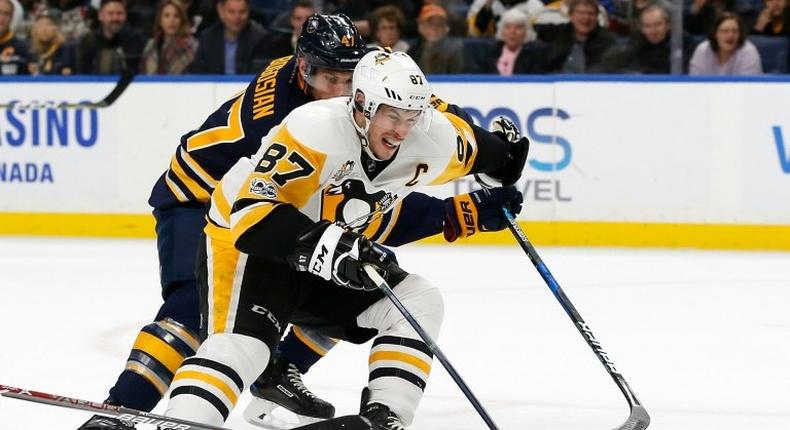 Sidney Crosby of the Pittsburgh Penguins scores with one hand on a breakaway as Zach Bogosian of the Buffalo Sabres tries to defend during the first period, at the KeyBank Center in Buffalo, New York, on March 21, 2017