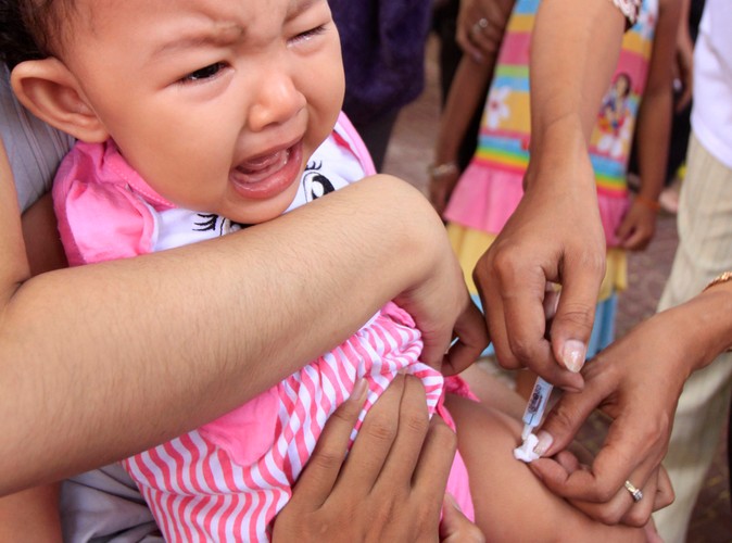 Boli, ale na pewno pomoże. Kambodżańskie dziecko szczepione przeciwko świńskiej grypie w kwietniu 2010 roku