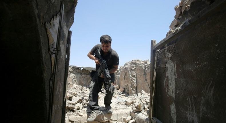 A member of the Iraqi Counter-Terrorism Service secures a building in the old quarter of Mosul, which a coalition general says will be free of Islamic State group fighters by next week